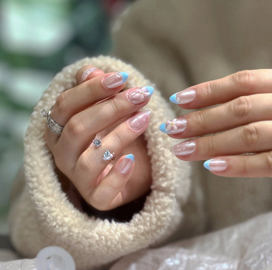Close-up of the delicate seashell or pearl details on the French tip press on nails.