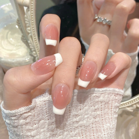 Close-up of the crisp French tip on the nude press on nails.