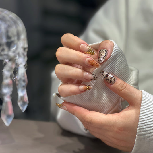 Tsuki Nails Golden Mane press-on nails with leopard spots and 3D gold charms.