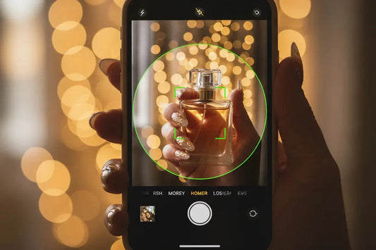 Hand with glitter press on nails by Tsuki Nails holding a perfume bottle, captured on smartphone