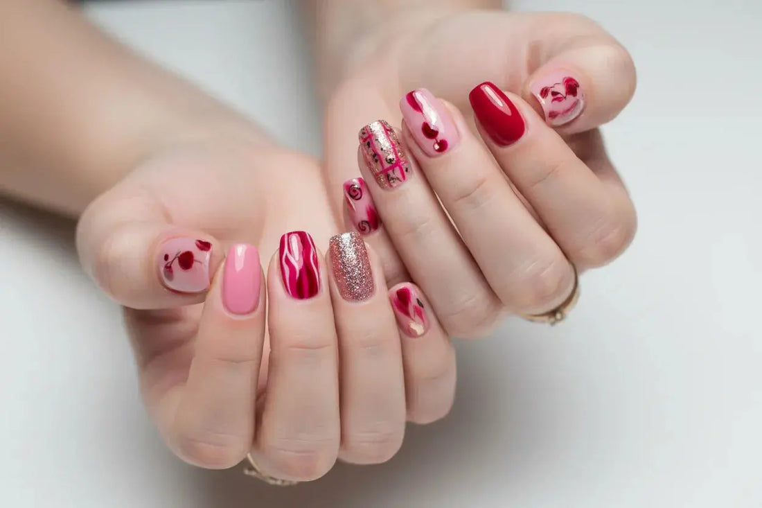Interlaced hands displaying Tsuki Nails press on nails with pink, red, and glitter designs.