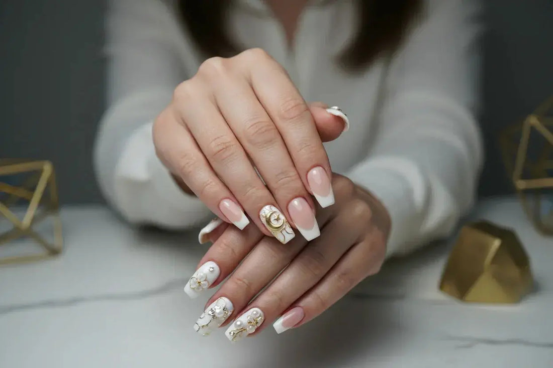 Woman's hands displaying salon-quality press on nails with French tips and floral designs