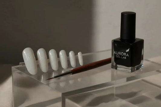 Set of white high gloss gel press on nails on clear stand with nail art brush and gel polish