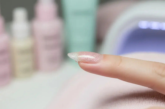 Close-up of a Tsuki Nails glitter press on nail being applied for a seamless salon look