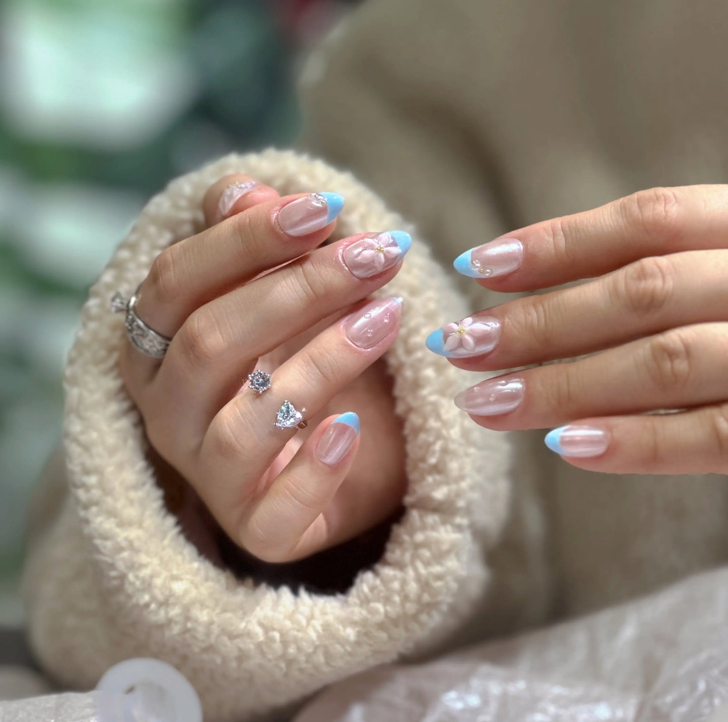 Close-up of the delicate seashell or pearl details on the French tip press on nails.