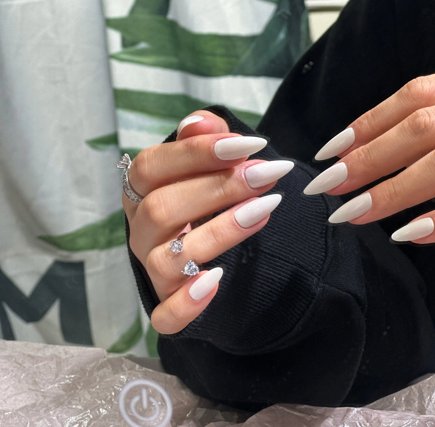 Close-up of the sleek stiletto nail shape and smooth ivory finish, side view.

