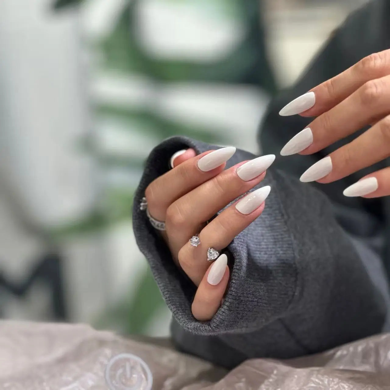 Minimalist ivory stiletto fake nails shown on hand, demonstrating length and elegance.