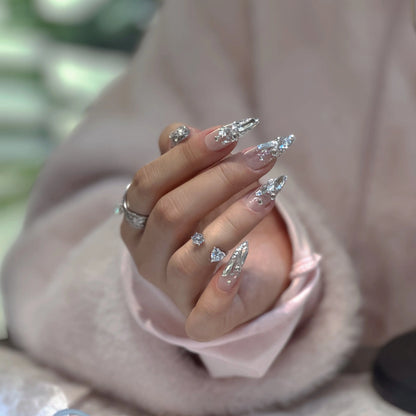 Close-up of the silver star accents and metallic glitter on the nails.


