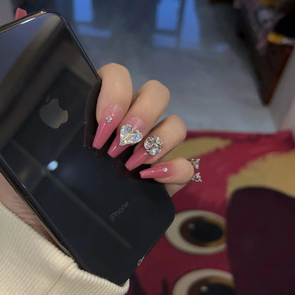 Close-up of the hand-set crystals and heart-shaped center gem on the nails.

