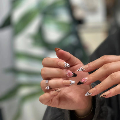Close-up detail showing the animal print texture and cherry blossom artwork on the nails.


