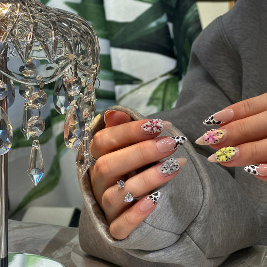 Close-up of the bold cow-print pattern on the French tips.

