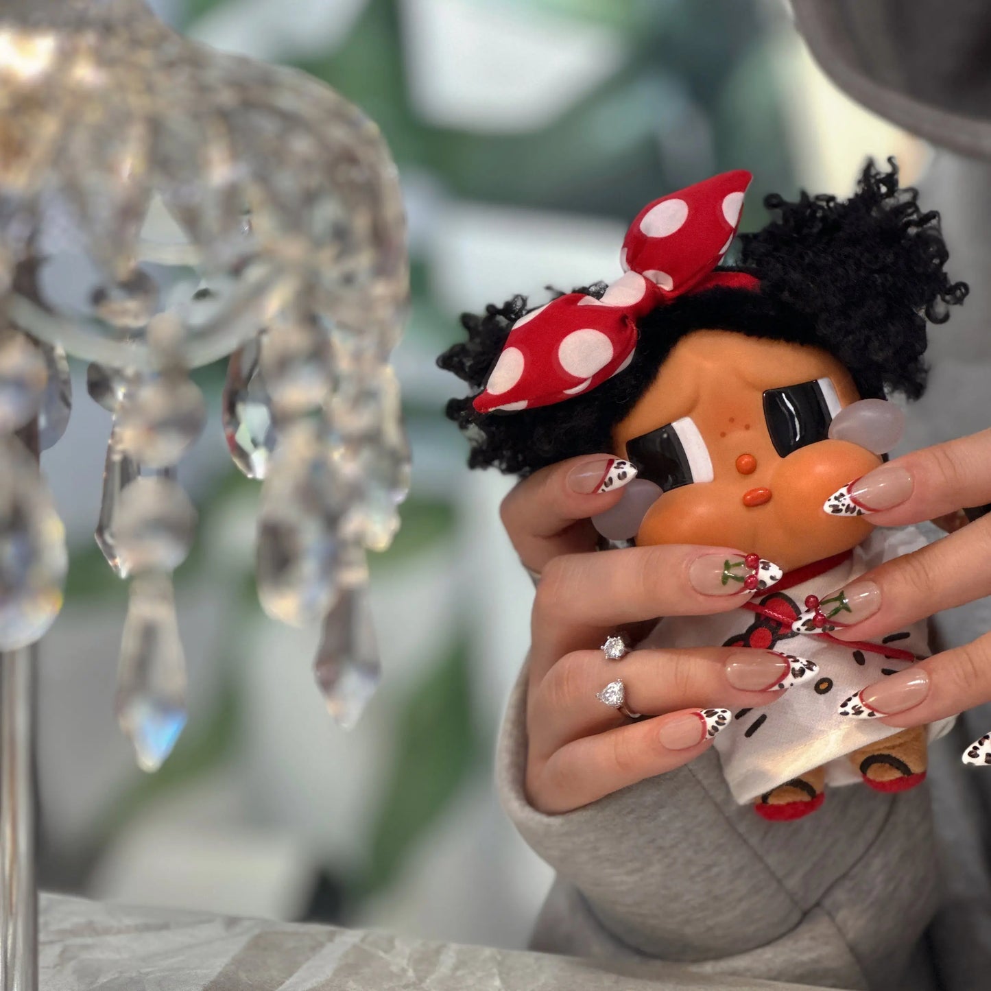 Close-up of leopard speckles and red cherry details on the nails.

