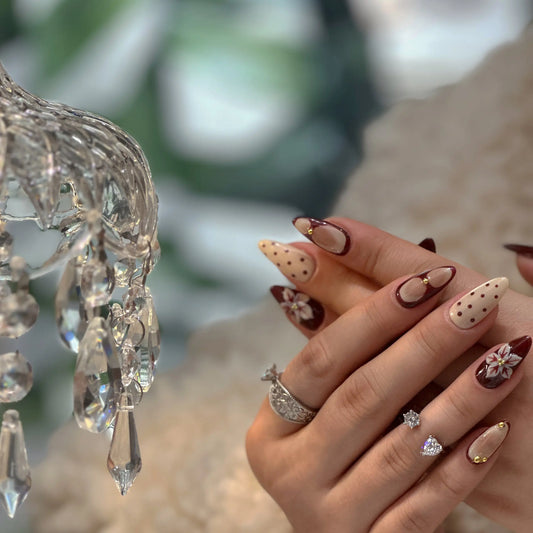 Close-up of frosted glitter on cranberry French tip nails.