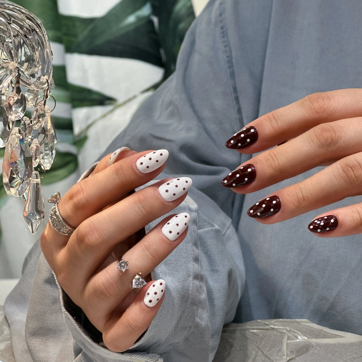 Side view of oval press on nails with choco dots design, worn on natural nails