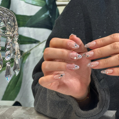 Natural-looking manicure with Starlight Glow sheer glitter press on nails, glowing like the night sky.

