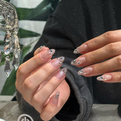 Close-up of the sparkling starry glitter on the sheer nude nails.

