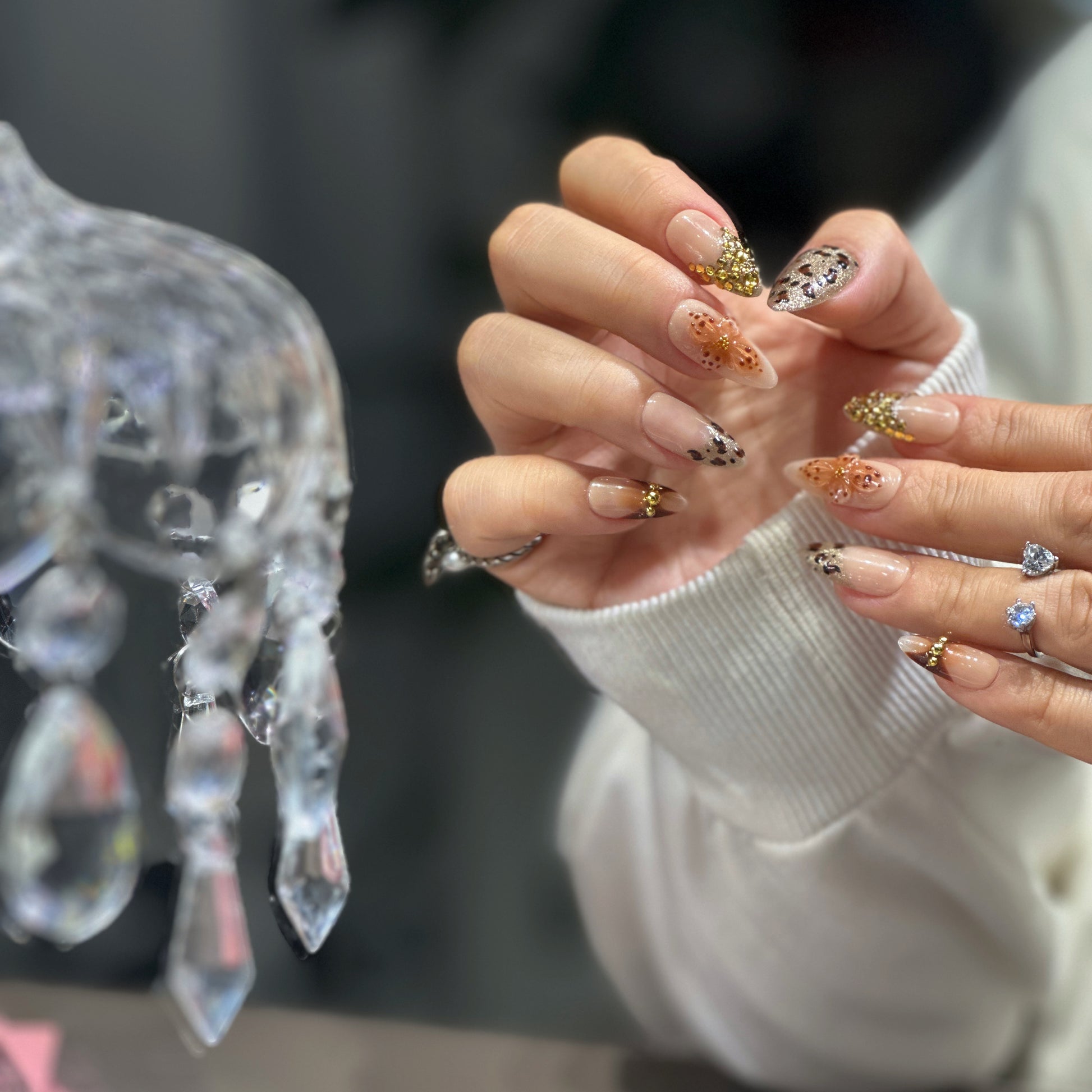 Leopard print and gold 3D accents on nude-gold ombré press-on nails.