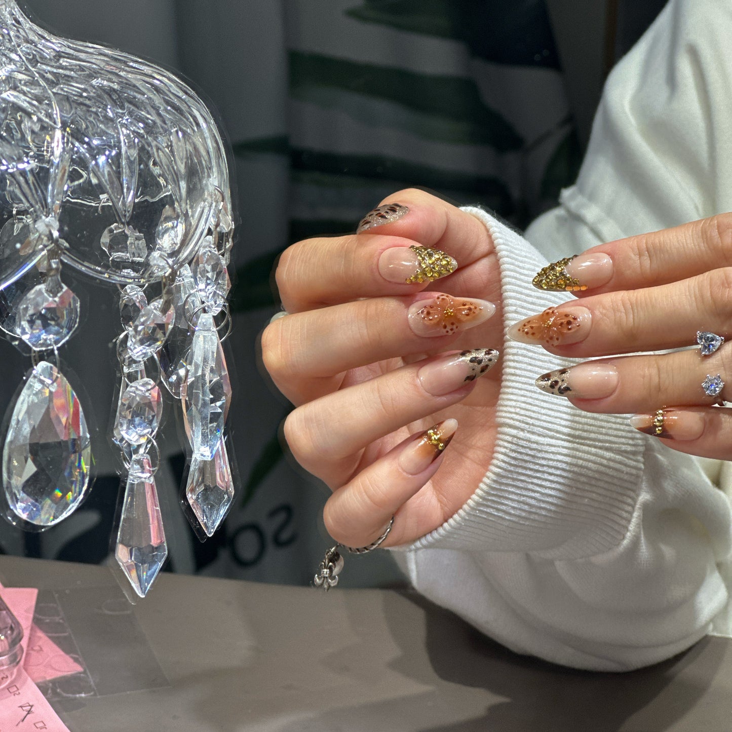 Handmade press-ons: leopard pattern, gold florals, and metallic details by Tsuki Nails.
