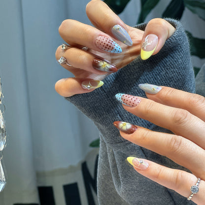 Hand modeling Starry Dots nails displaying burgundy ombre, pink-blue polka dots and 3D white flowers
