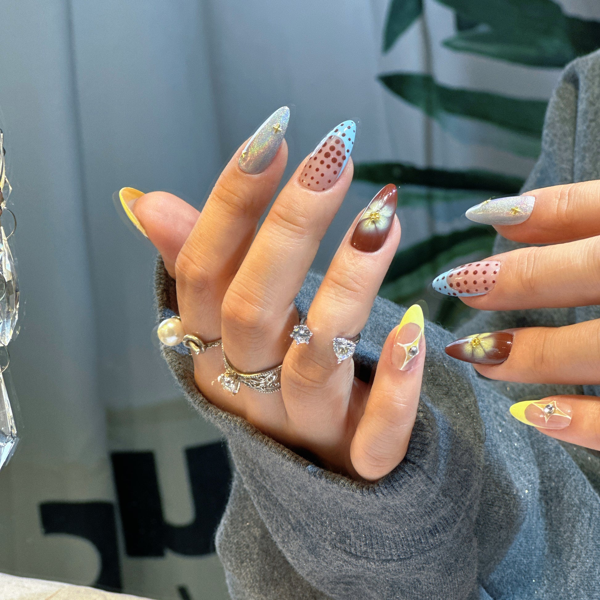 Both hands wearing Starry Dots nails showing complete eclectic design with stars, dots and floral accents
