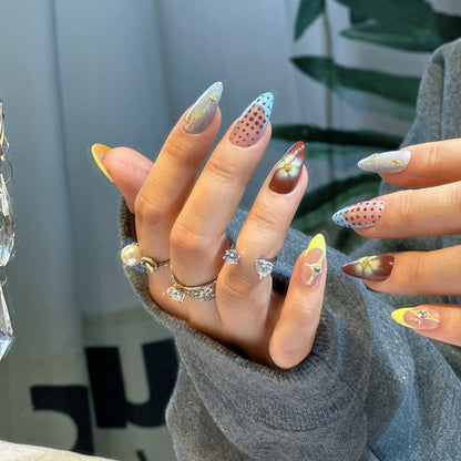 Both hands wearing Starry Dots nails showing complete eclectic design with stars, dots and floral accents
