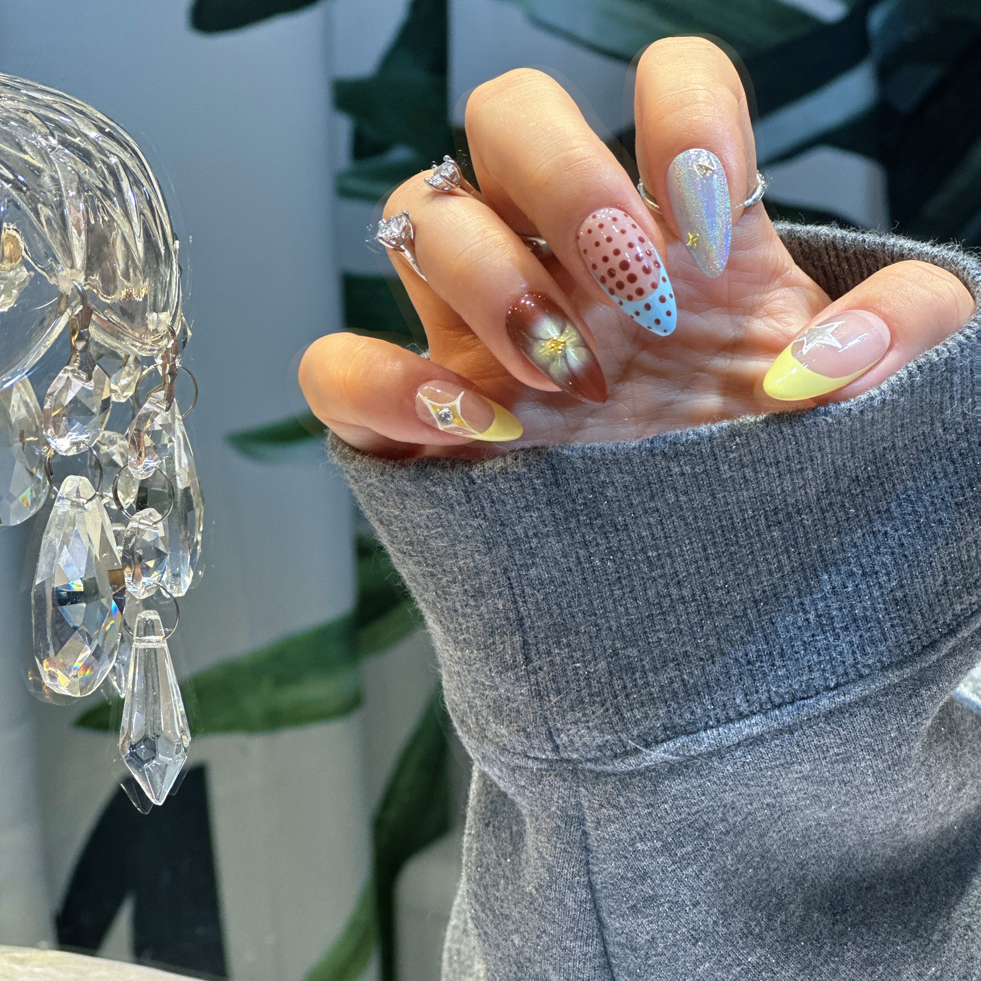 Side angle of Starry Dots press-on nails with silver chrome, polka dot patterns and dimensional flower details
