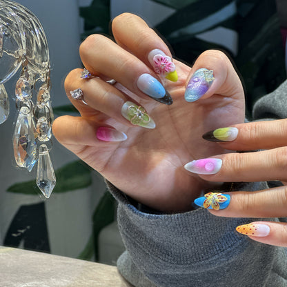 Detail view of Rainbow Garden nails showing white base with rainbow ombre, 3D flowers and glossy finish
