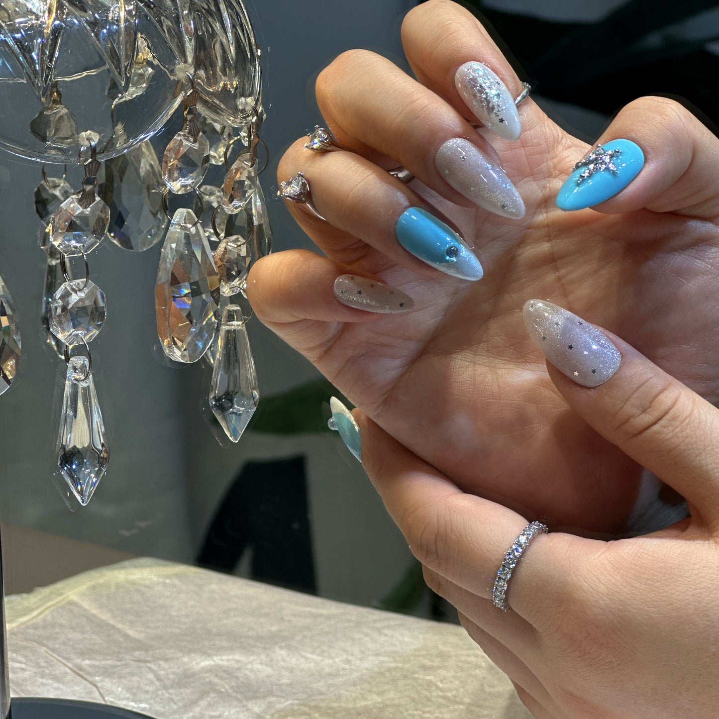 Both hands wearing Celestial Cross nails with heavenly blue and white tones, crystal crosses and rhinestone details
