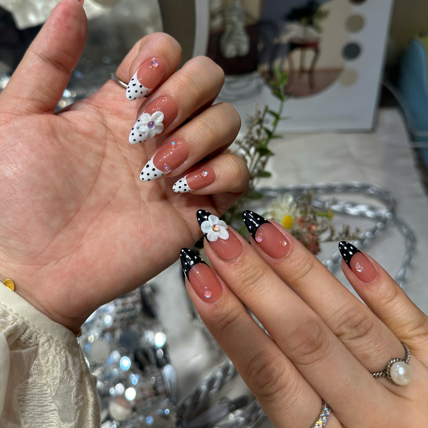 Side angle of Polka Dot Bloom press-on nails showing aurora crystal details with glossy black and white French tip finish
