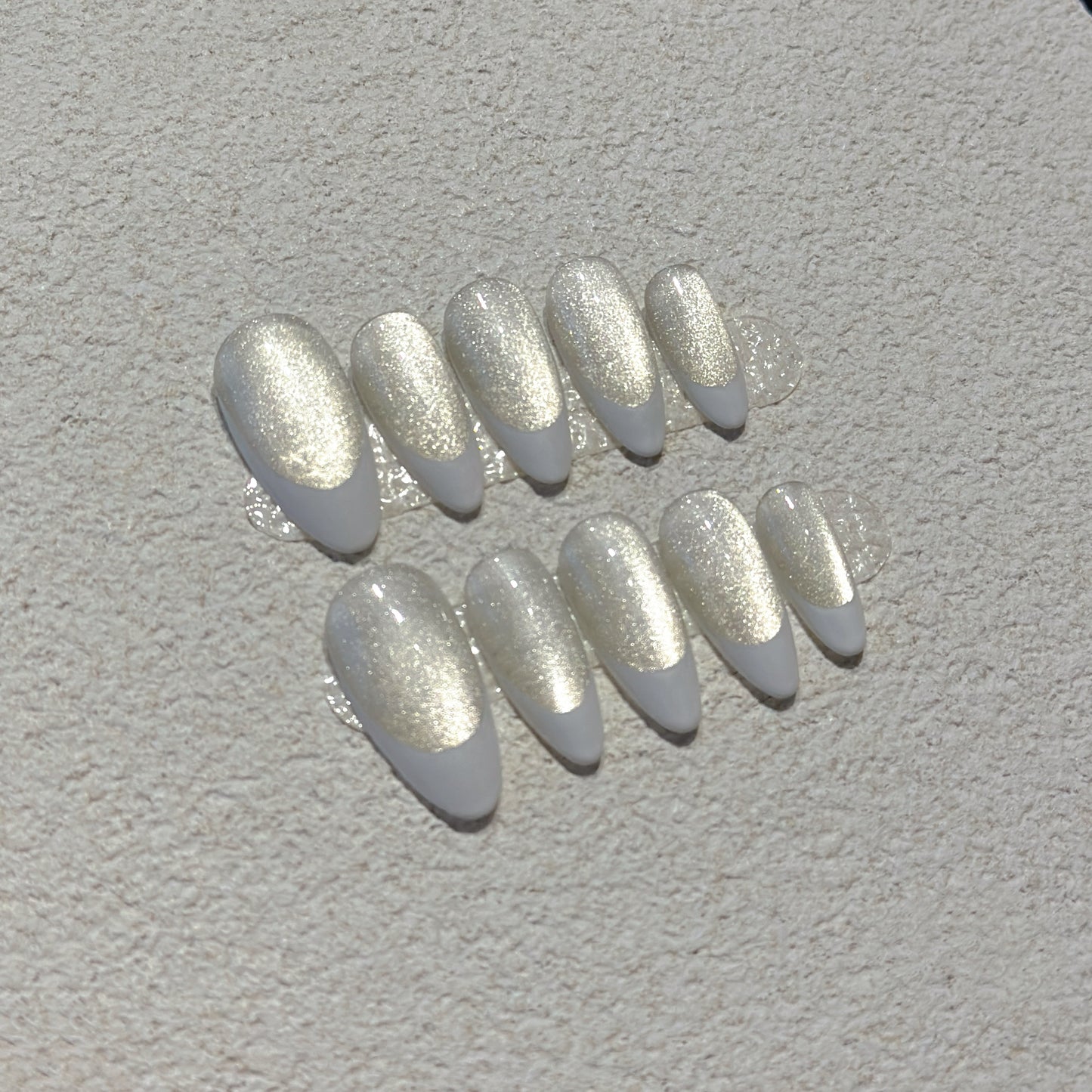 Pearl French Shimmer press-on nails showing milky nude base with crisp white French tips and champagne silver shimmer
