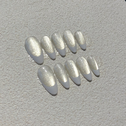 Pearl French Shimmer press-on nails showing milky nude base with crisp white French tips and champagne silver shimmer
