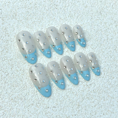 Blue French Crystal Rain press-on nails flat lay with sheer transparent base, sky-blue French tips and scattered silver crystal rhinestones
