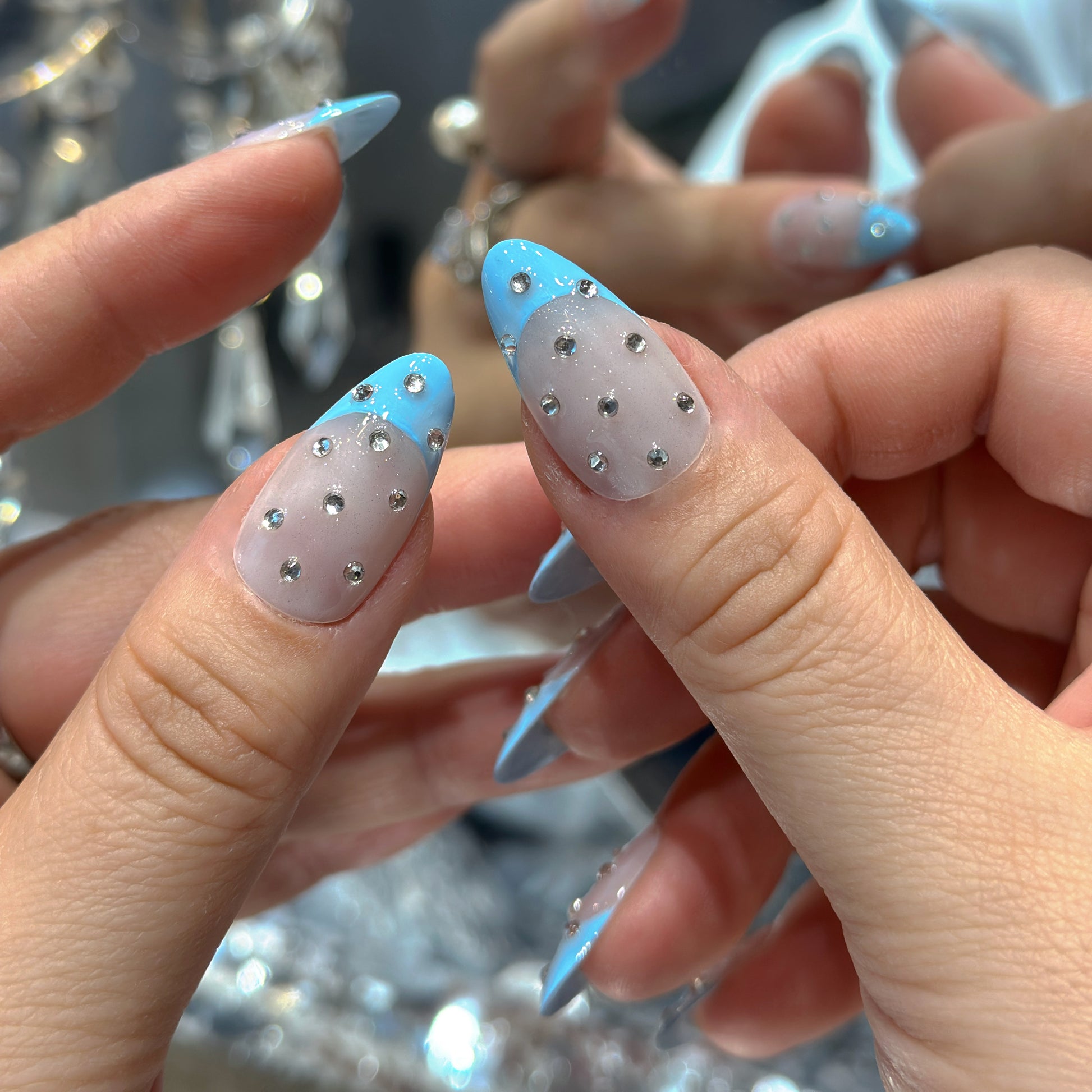 Both hands wearing Blue French Crystal Rain nails showing sky-blue French tips with cascading silver crystal rhinestone details

